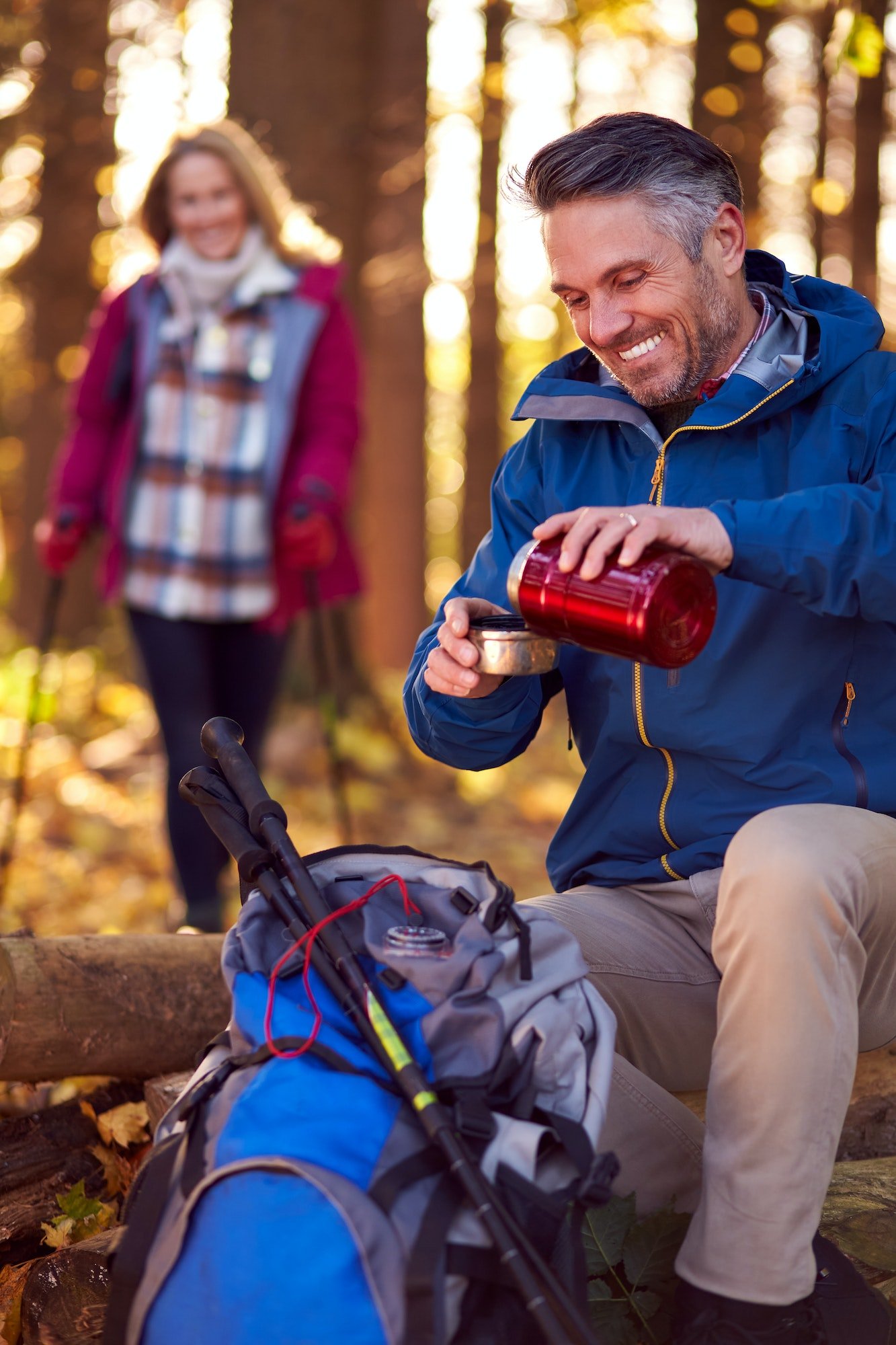 Mature Retired Couple Stop For Rest And Hot Drink On Walk Through Fall Or Winter Countryside